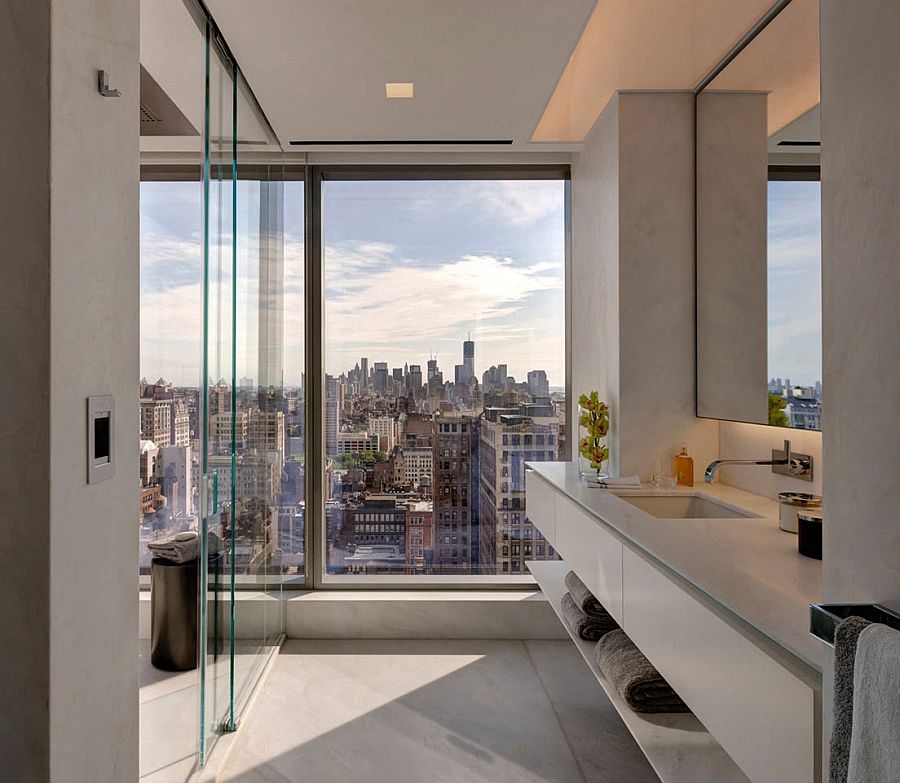 Glass walls separate the bedroom from the bathroom