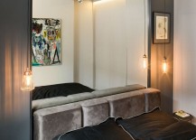 Headboard-of-the-bed-mimics-the-color-of-concrete-even-as-bedside-lighting-saves-up-space-217x155