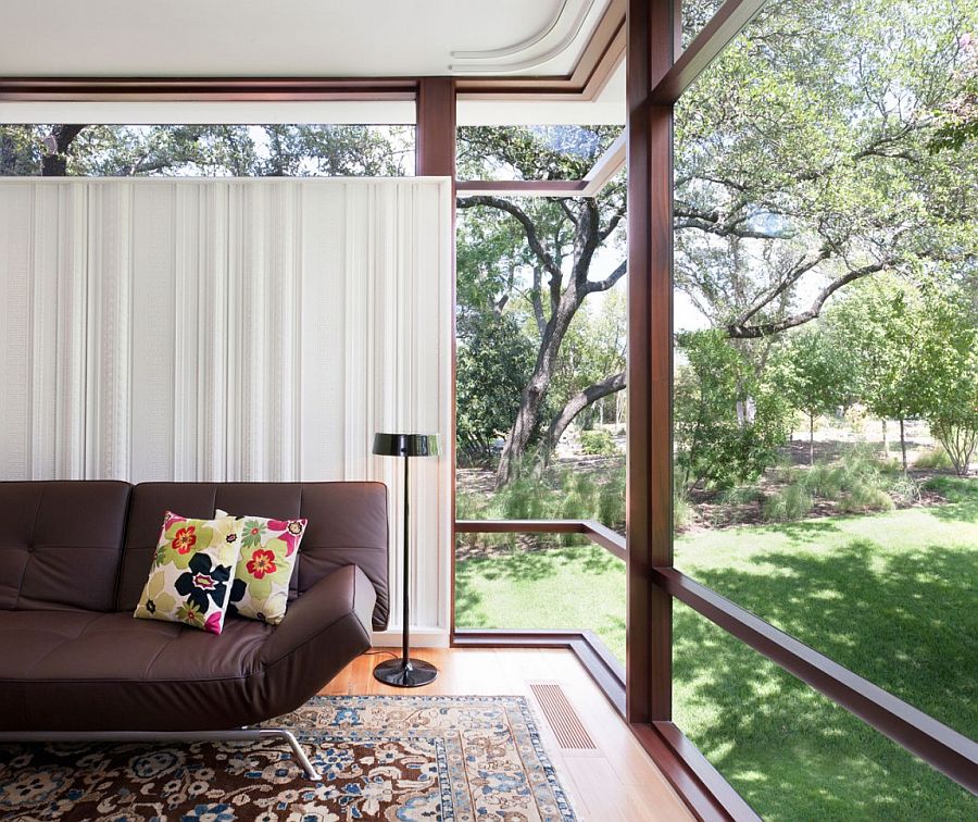 Large glass windows open up the sitting area to the lush green landscape outside