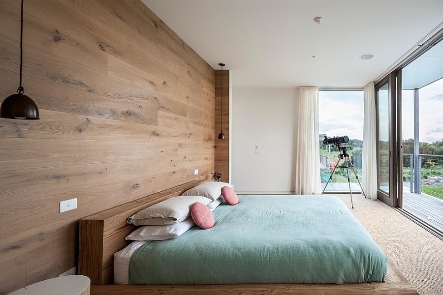 Lovely bedroom with bedside pendant lights and wooden headboard wall