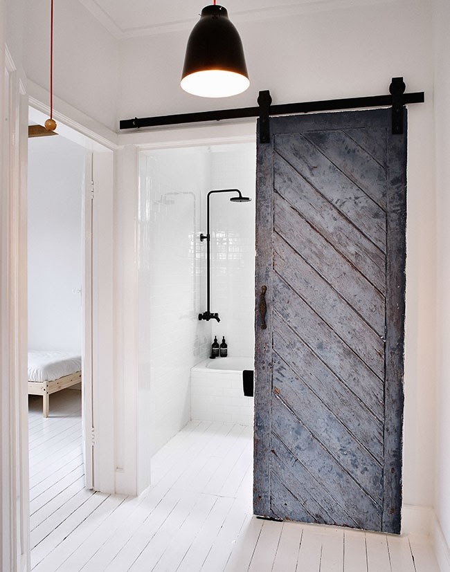 Reused old barn door creates a fabulous entrance for the scandinavian bathroom