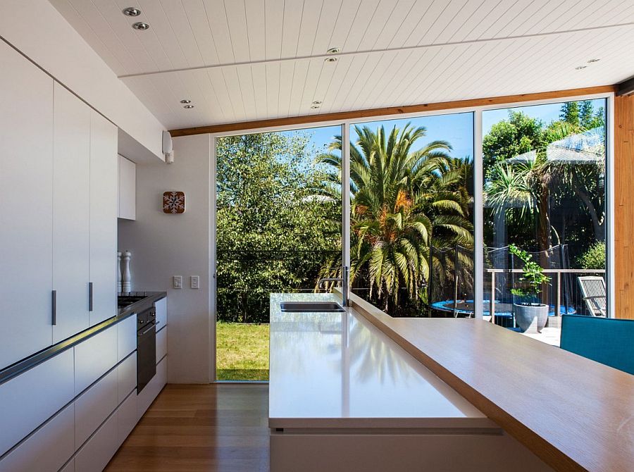 Sleek modern kitchen of the Auckland home overlooking the landscape outside