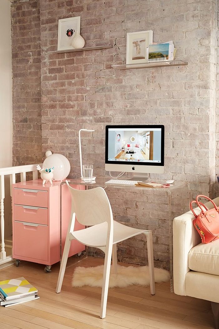 Small corner workspace with transparent desk and a pastel pink cabinet