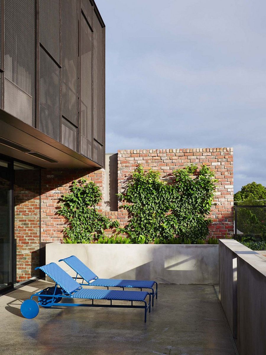 Small private porch of the melbourne how with a brick backdrop and colorful loungers