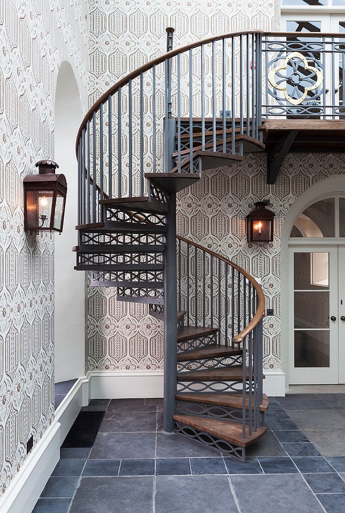 Space-saving spiral staircase with a backdrop draped in wallpaper