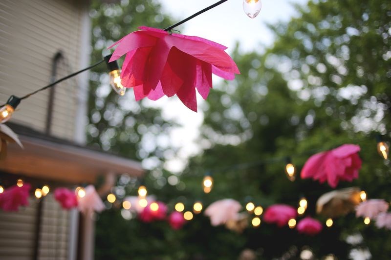 Tissue paper flowers embellish a string of outdoor lights