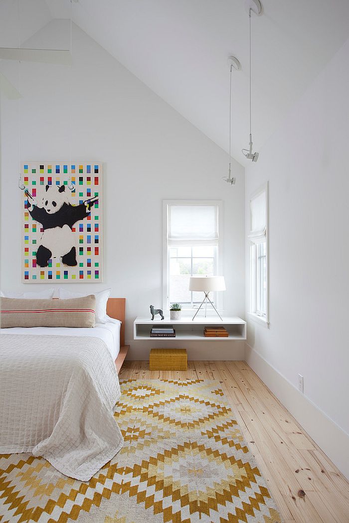 Wall art and chic rug add color and pattern to the stylish Scandinavian bedroom [Design: Texas Construction Company]