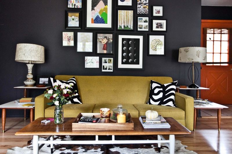 A gallery grouping of art pops against black walls