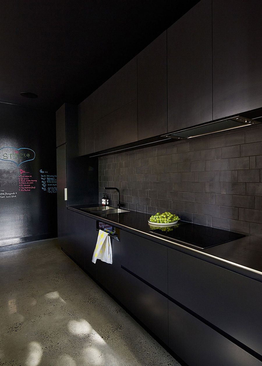 Black kitchen idea with tiled backsplash and a chalkboard wall