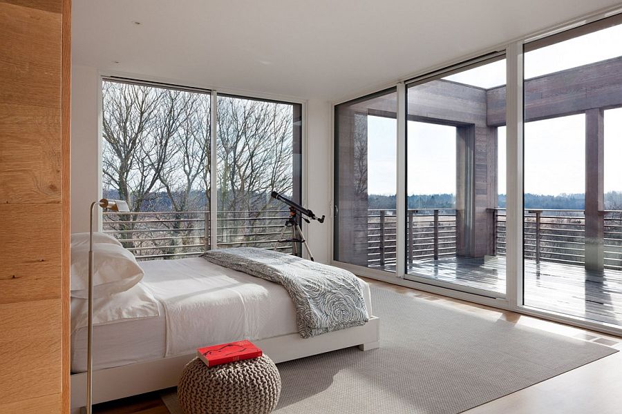 Large sliding doors and windows open the master bedroom towards the view outside