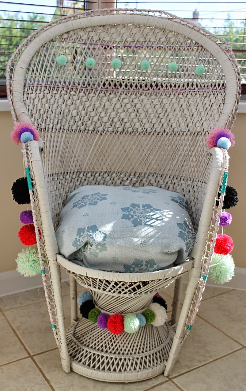 Pom poms adorn a woven peacock chair