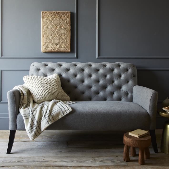 Tufted settee in a grey room with grey trim