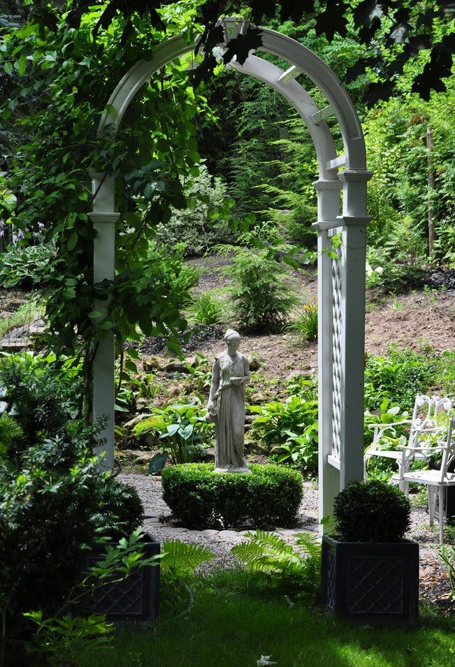 Classic garden design with archway and statue