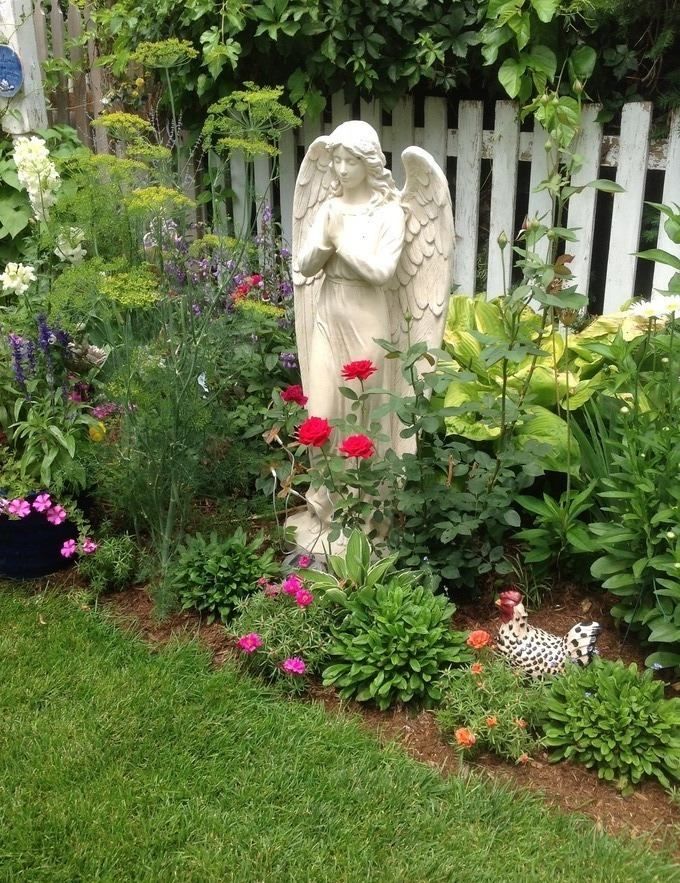 Статуя в саду с цветами