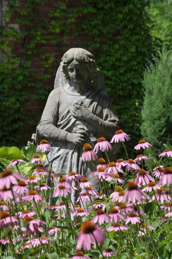 Tall garden statue surrounded by lovely flowers