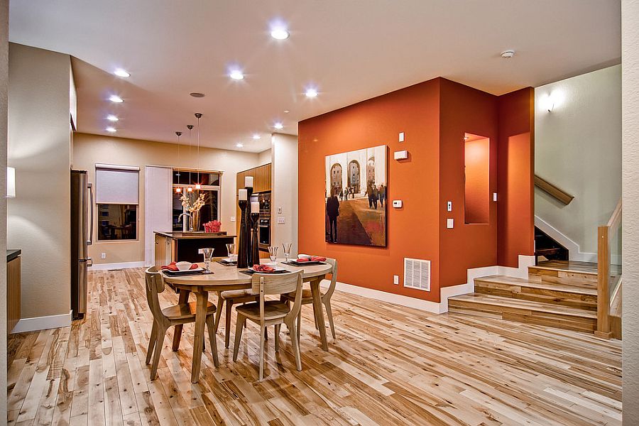 An orange backdrop for contemporary dining space in open plan living area