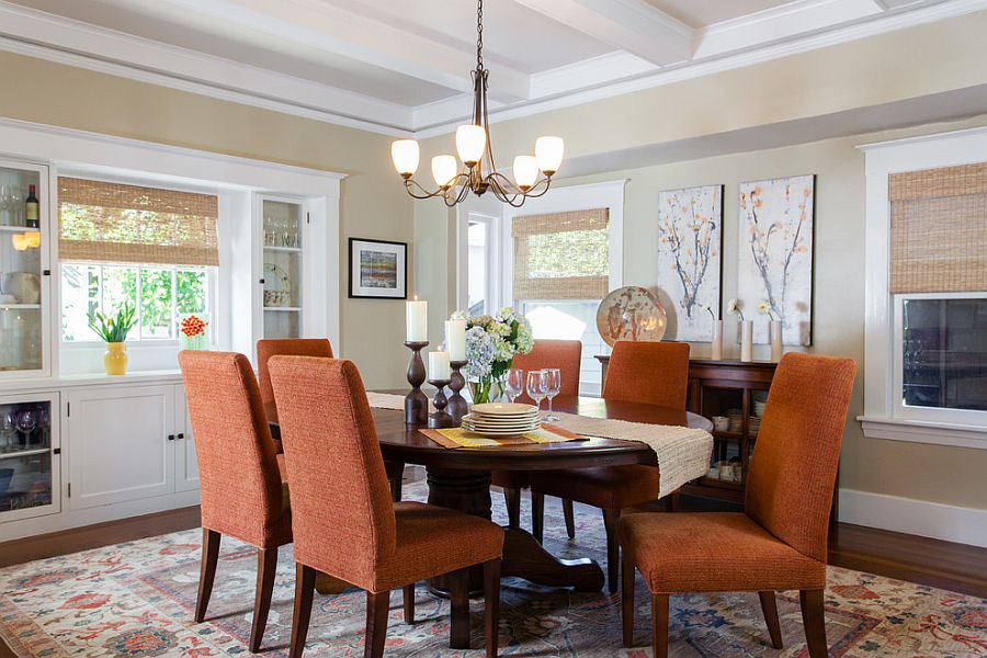 Beautiful orange chairs bring color to the traditional dining room