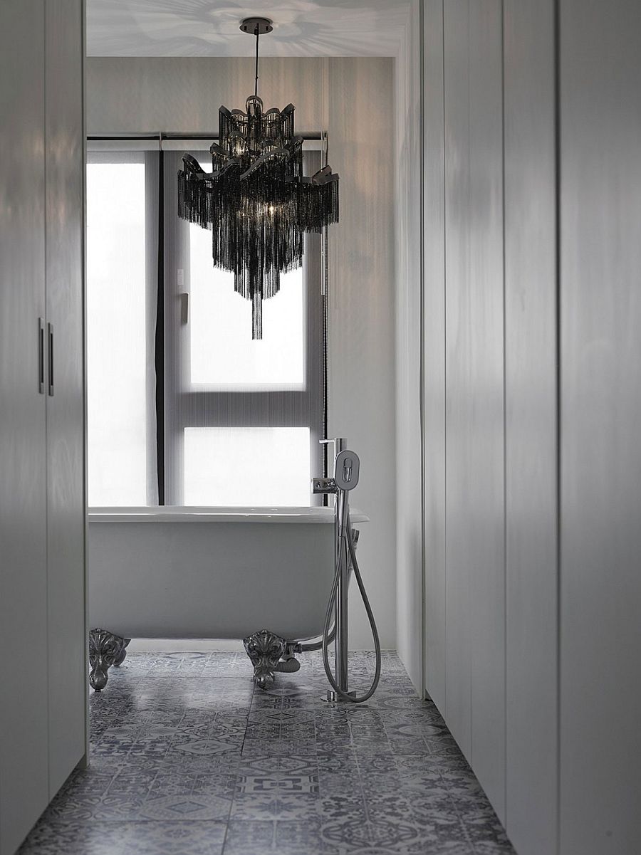 Chandelier above the bathtub adds dark contrast to the interior