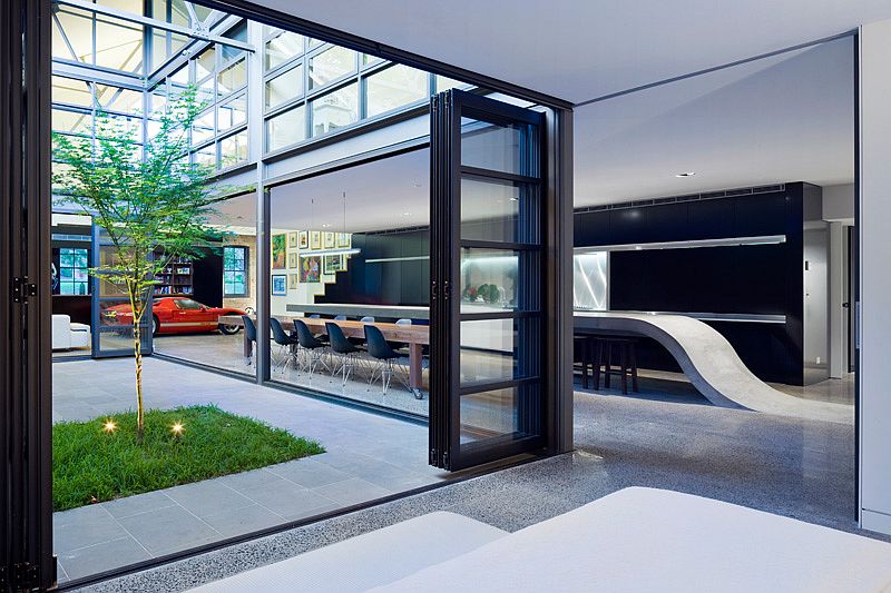 Large glass doors and windows create seamless interface between interior and courtyard