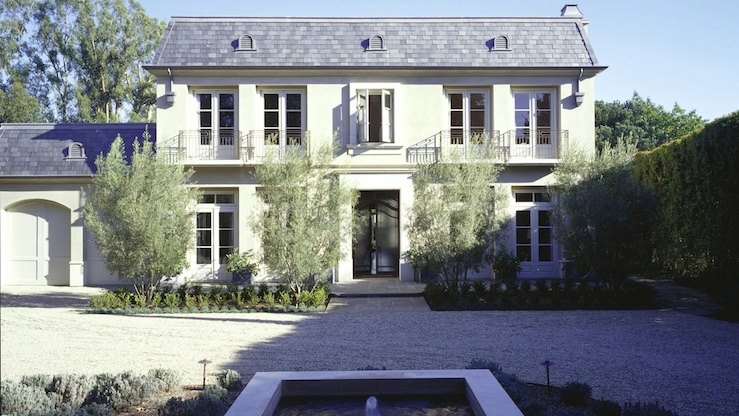 Large stucco home with a shingled roof