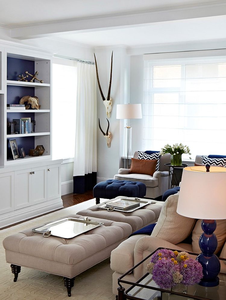 Tufted ottomans with modern silver trays double as coffee tables