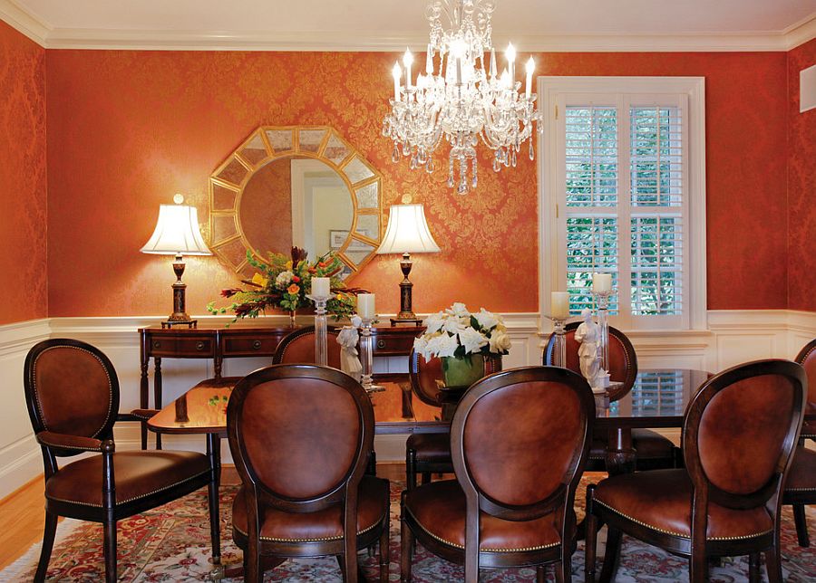 Wallpaper in orange and gold brings an air of luxury to the classy dining room