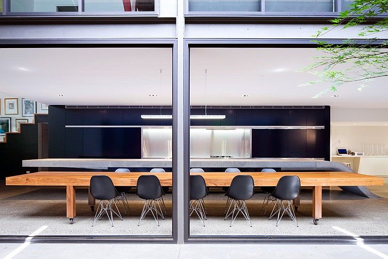 Wooden dining tables stands in contrast to the concrete kitchen island