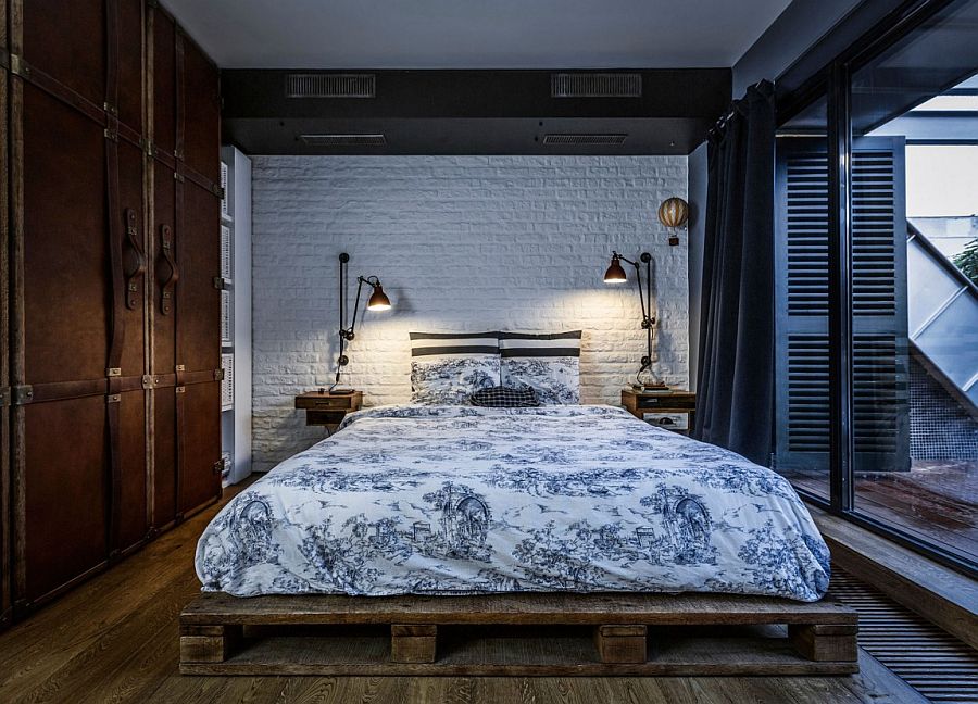 Bedroom with vintage suitcase-styled wardrobe and white brick wall