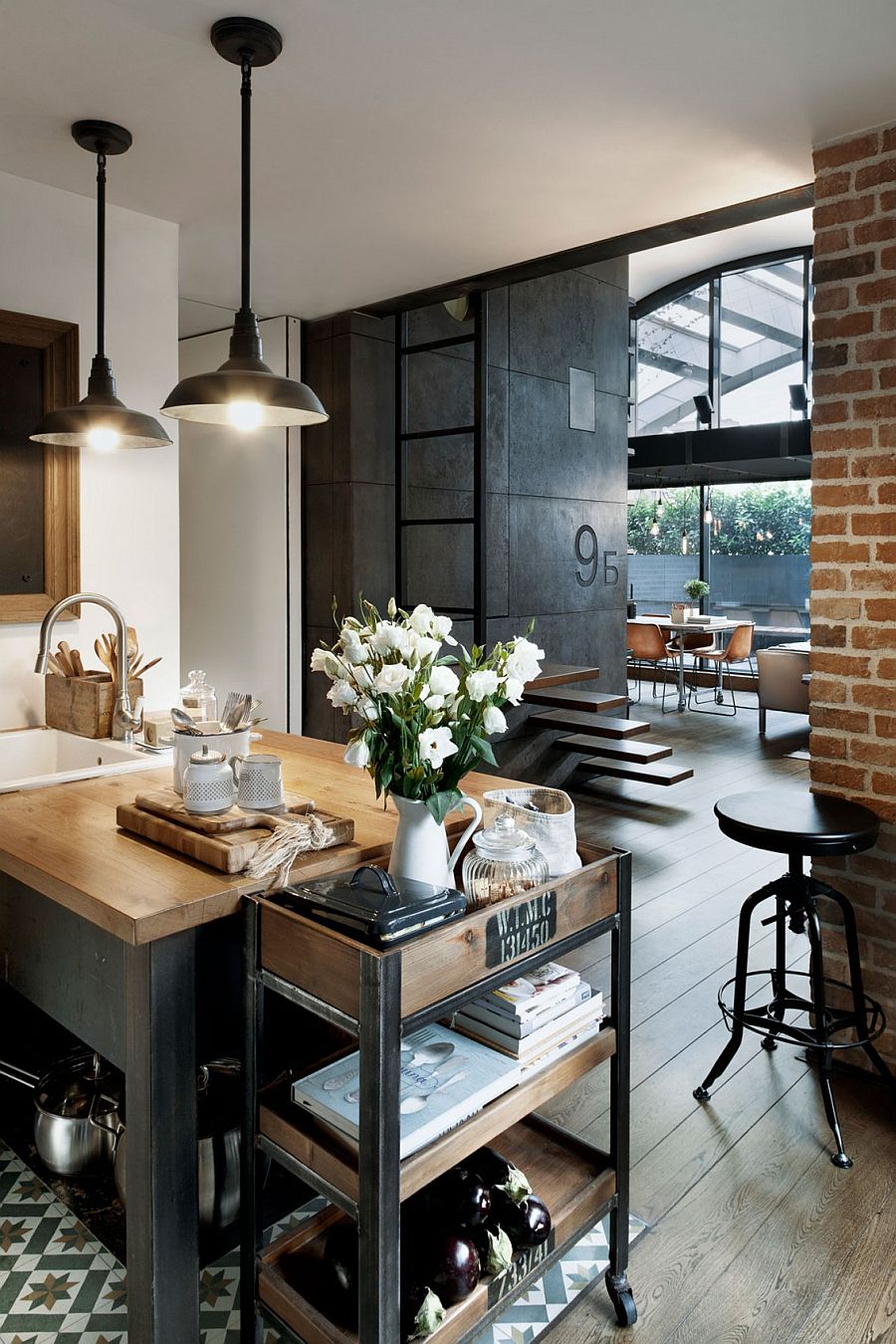 Custom crafted concrete panels, brick wall and lighting add industrial charm to the apartment