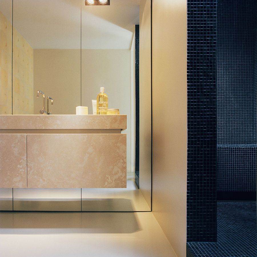 Dark tiles shape the shower area in the cozy bathroom