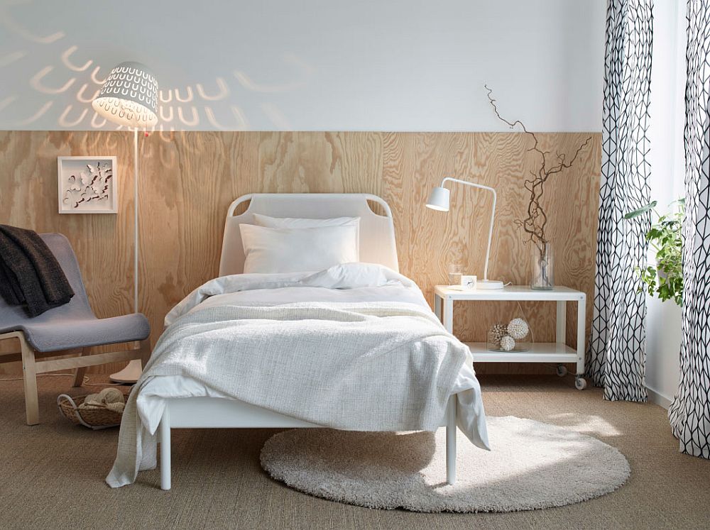 Elegant wooden bakdrop and TISDAG floor lamp create a refined ambiance in this small bedroom setup