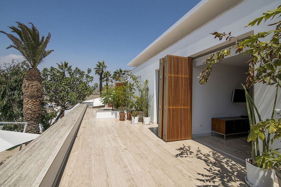 Foldable doors made from natural materials connect the interior with the social areas outside