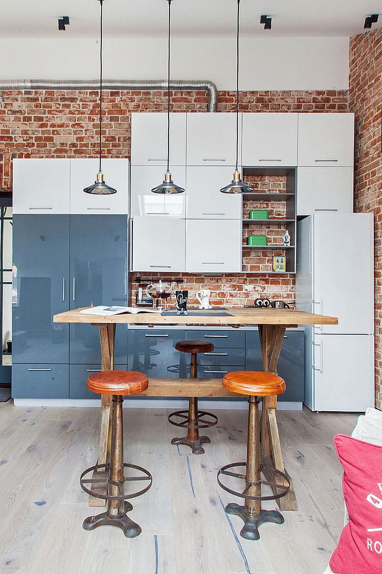 Glossy modern kitchen cabinets stands in contrast to the brick wall backdrop