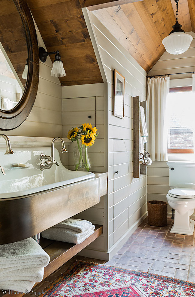 Gorgeous attic bathroom with wood ceiling and brick floor