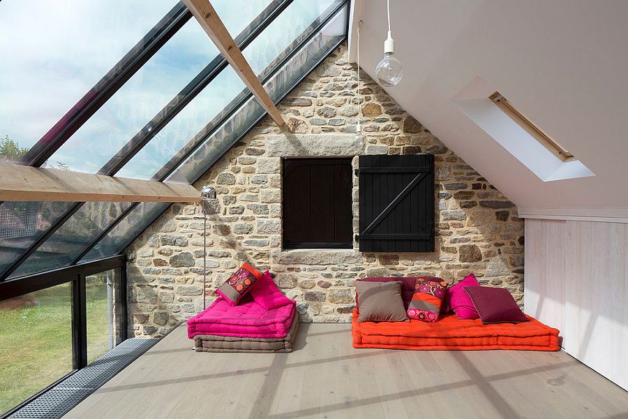 Gorgeous sunroom with informal seating along with stone and glass walls