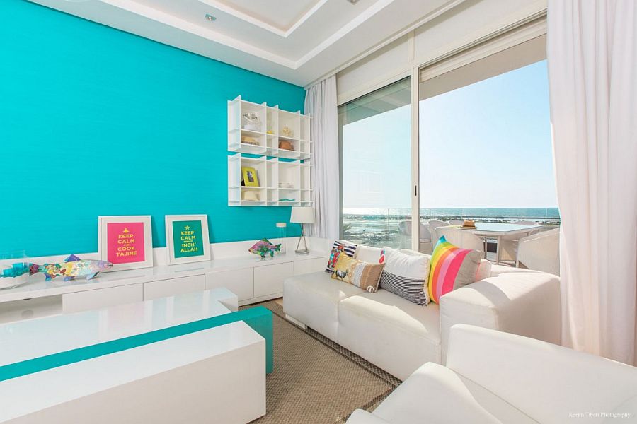 Large glass doors connect the living room with the balcony and ocean view outside