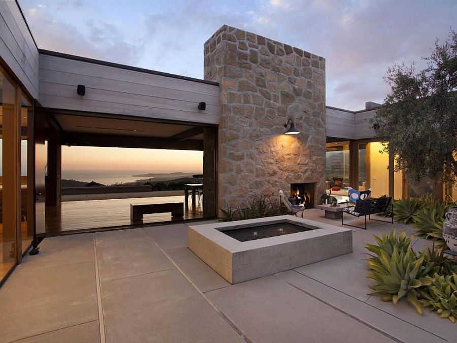 Large stone wall with fireplace shapes a cozy courtyard