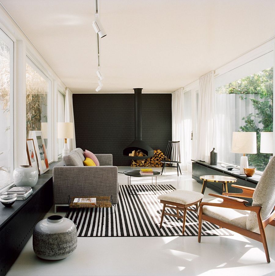 Living room with black accent wall, light pink ceiling and a contemporary fireplace