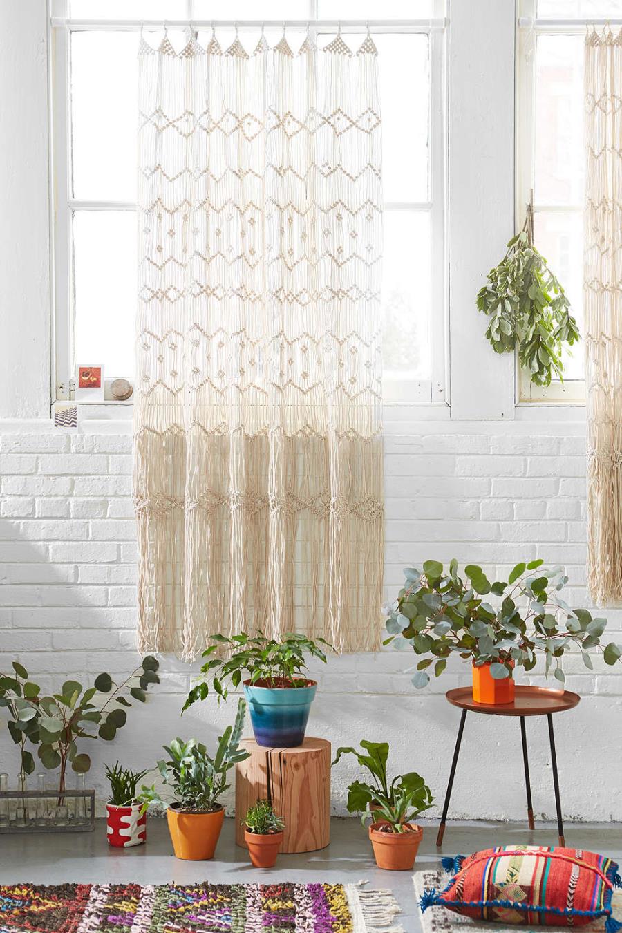 Macrame wall hanging against a white brick wall