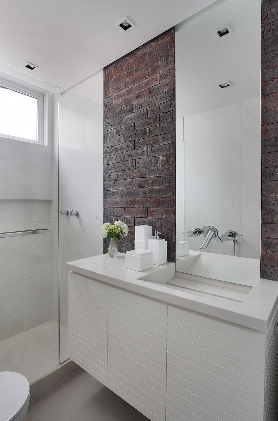 Modern bathroom in white with a brick wall