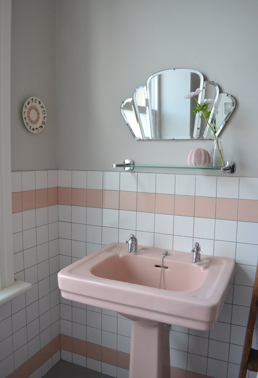 Pink pedestal sink in retro bathroom