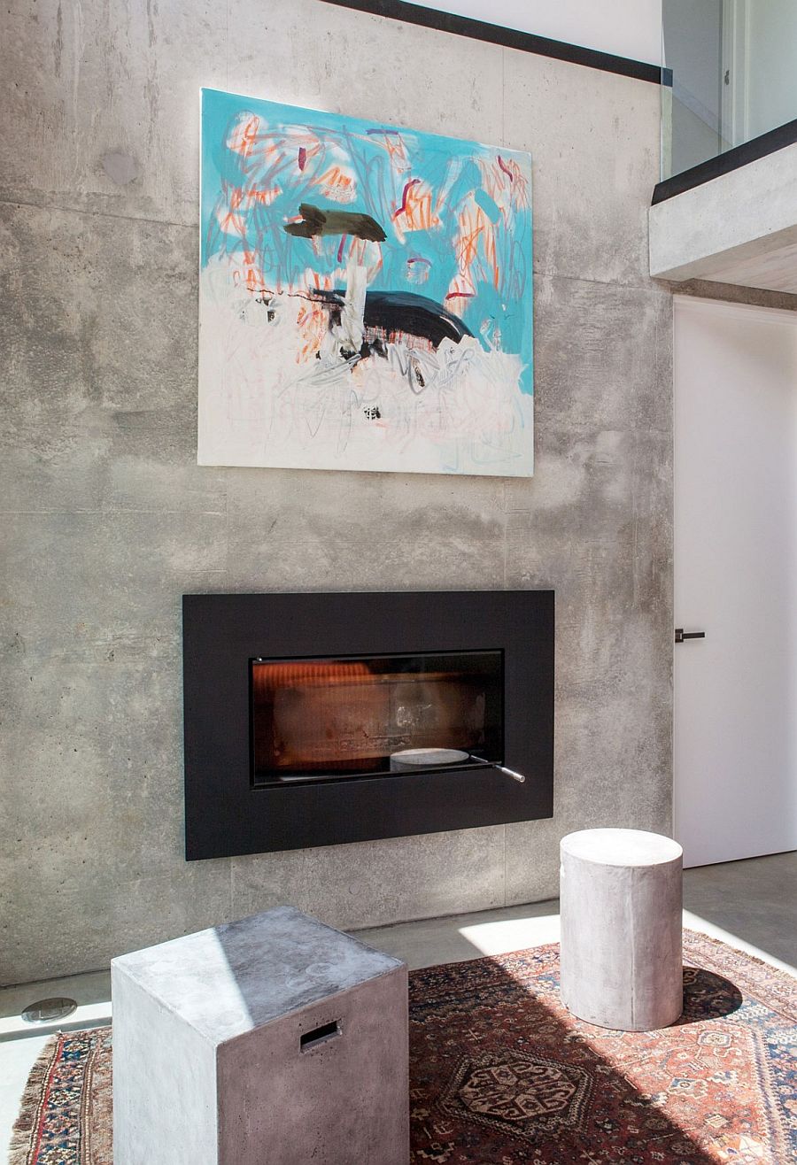 Precast concrete living room wall holds sleek modern fireplace and wall art