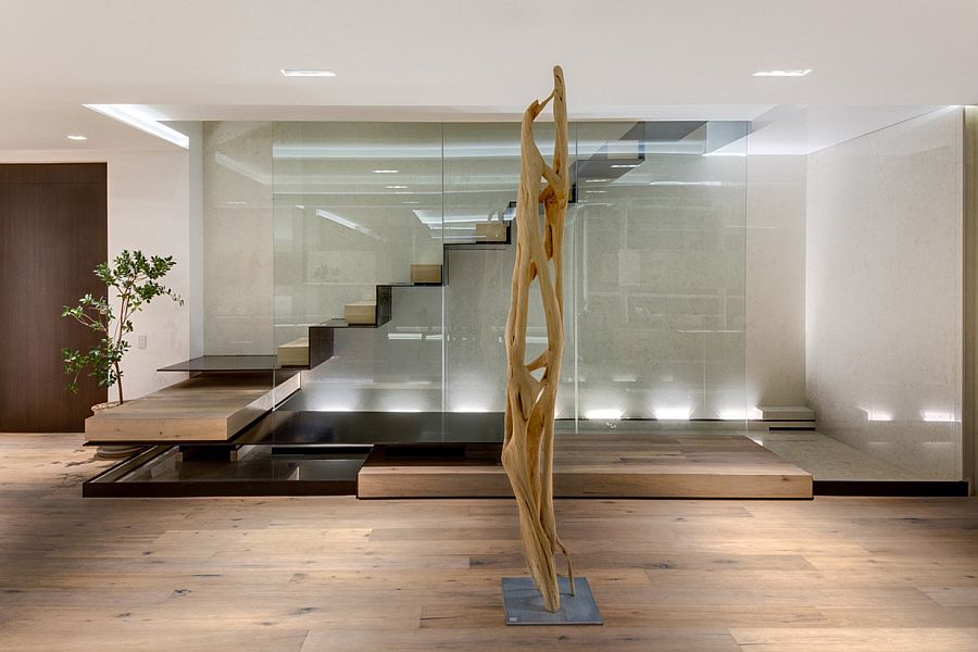 Sculptural floating staircase above pool of water in the living area