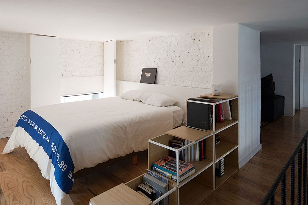 Small bedroom with white brick walls and organized shelf