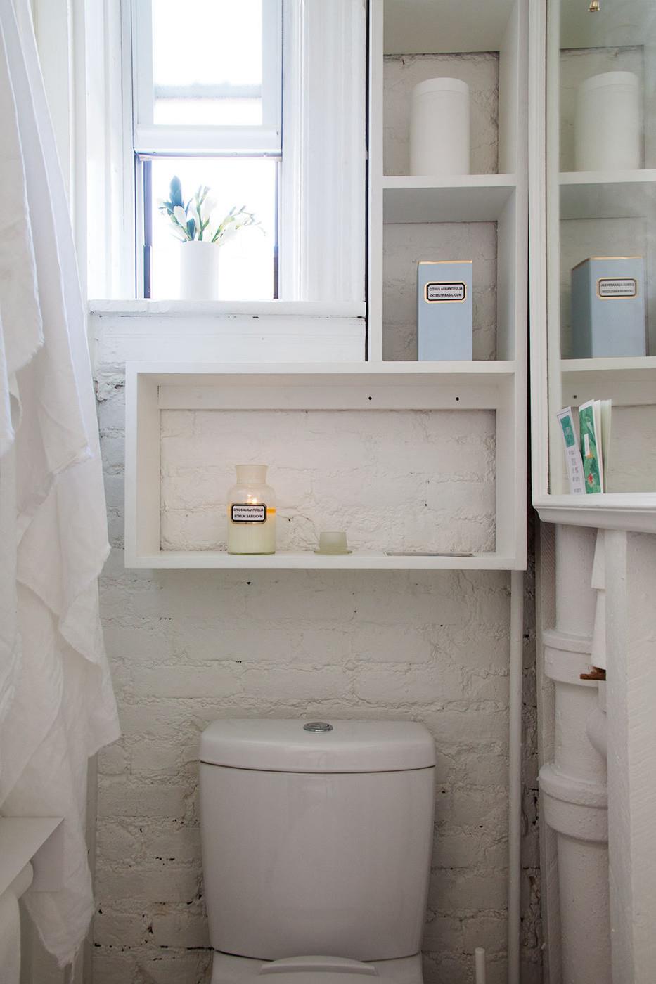 Small bright and airy bathroom with a painted brick wall