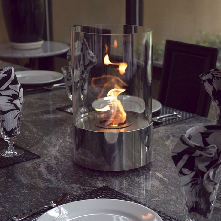 Small portable fireplace in modern glass cylinder