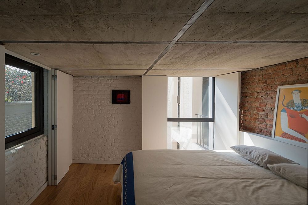 Smart way to decorate a bedroom with low concrete ceiling and brick walls