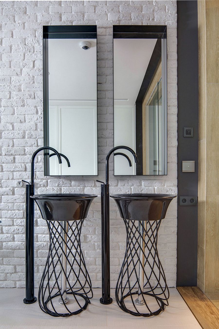 Trendy twin sinks in the bathroom with brick wall