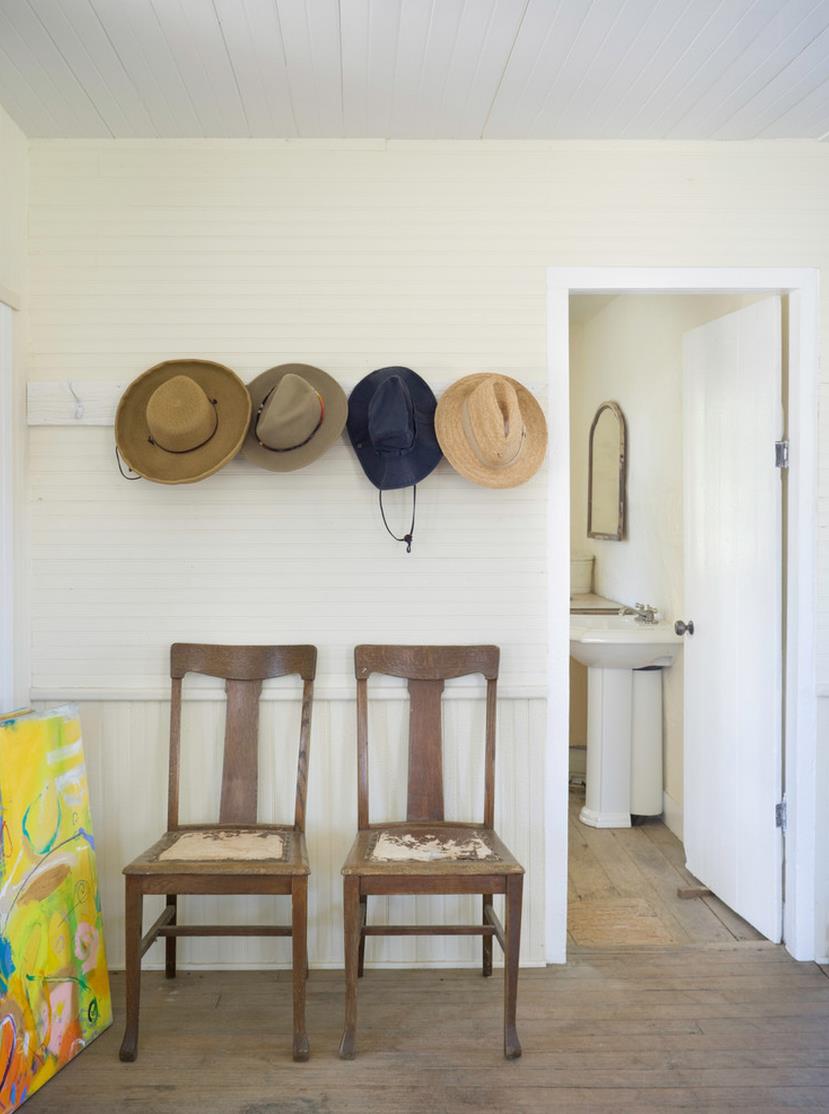 Wall-mounted hooks over a pair of entryway chairs