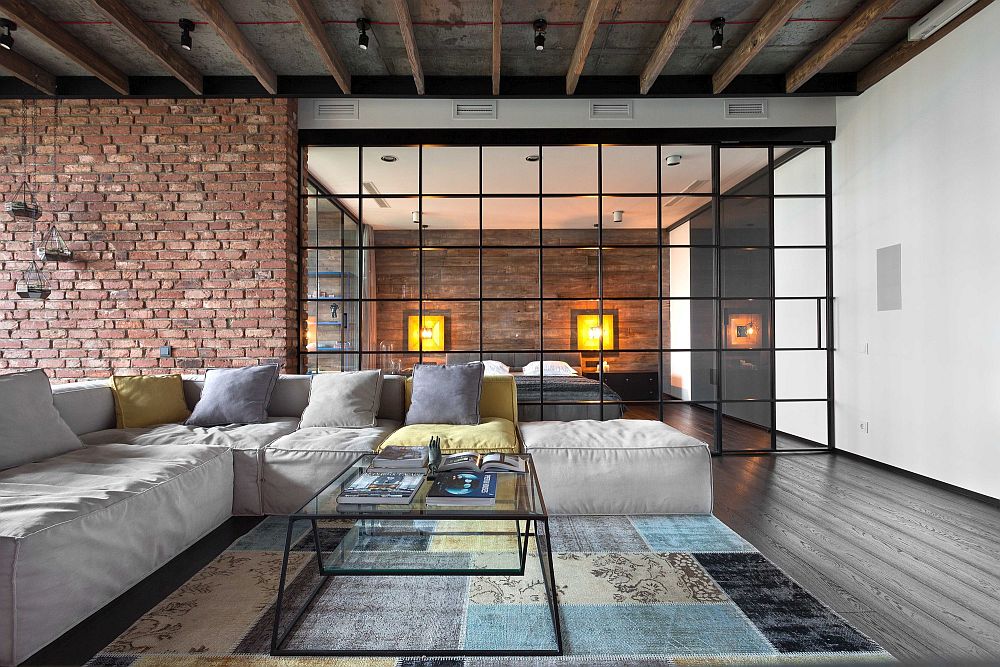 Wall of glass separates the living room from the bedroom inside the bachelor loft